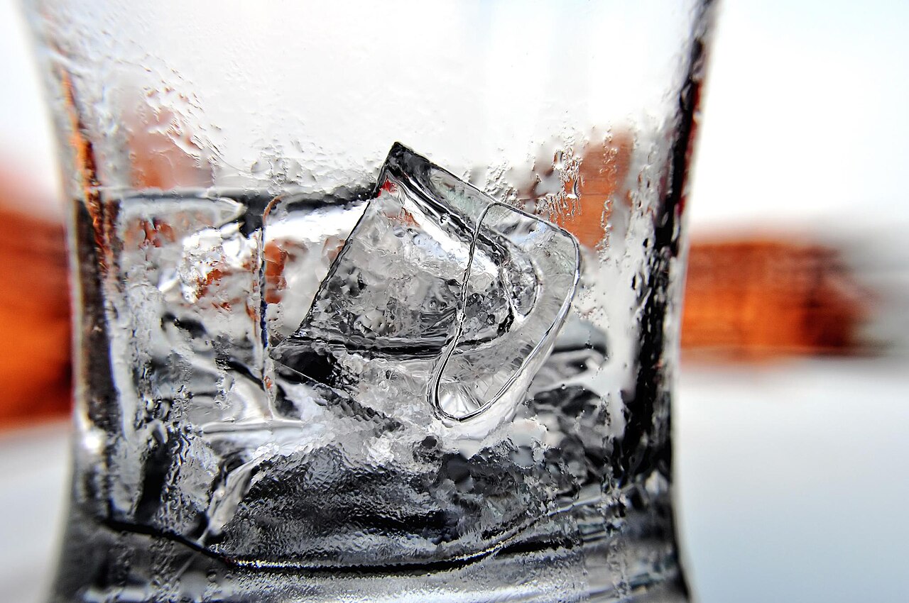Varios cubitos de hielo dentro de un vaso de cristal