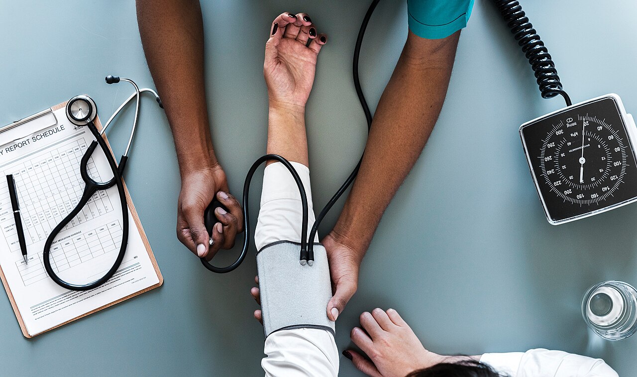 Una profesional sanitaria mide la presión arterial a una paciente con un tensiómetro de brazalete