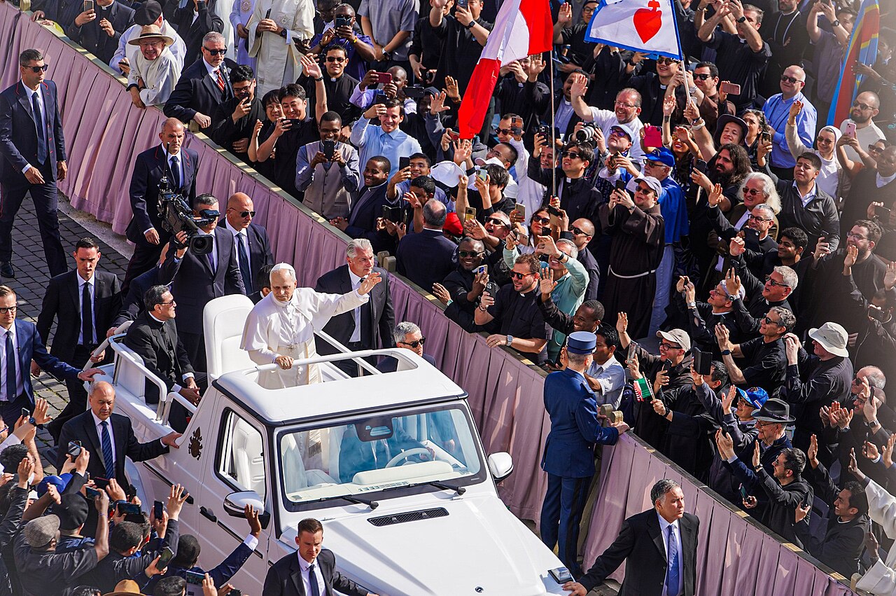 El papa León XIV, vestido de blanco, saluda desde el papamóvil ante una multitud en el Vaticano durante la misa de inicio de su pontificado, en mayo de 2025