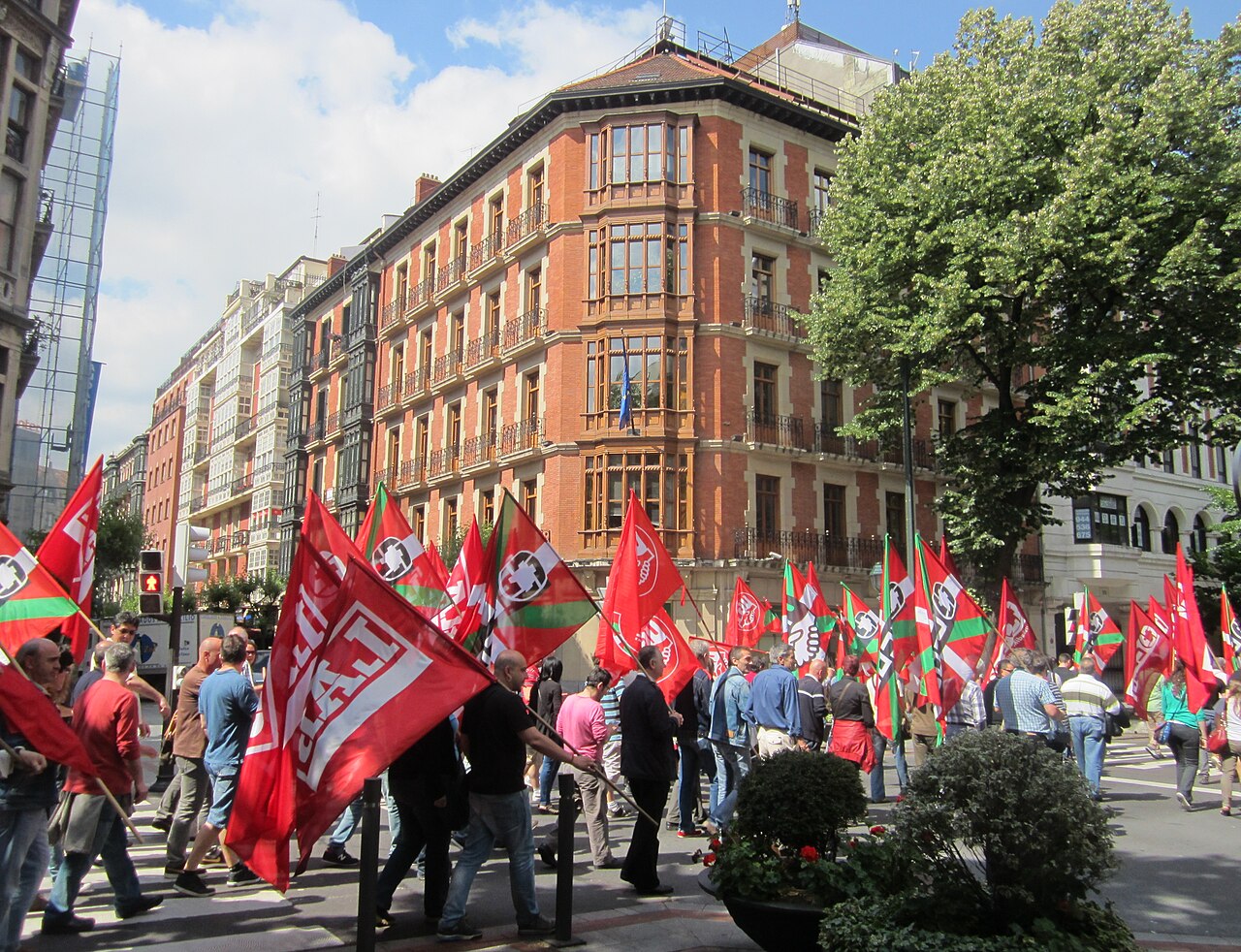 Manifestantes con banderas rojas de sindicatos recorren una calle de Bilbao durante una huelga en junio de 2013