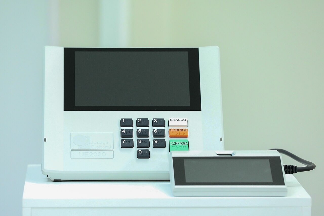 Urna electrónica brasileña modelo UE2020, con teclado numérico y pantalla, sobre un mueble blanco (imagen de archivo)