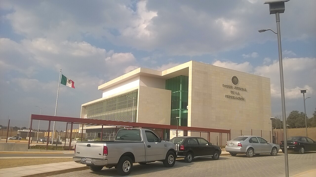 Edificio del Poder Judicial de la Federación en la Ciudad Judicial de Tlaxcala, con la bandera de México en un asta y varios autos estacionados delante